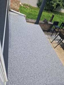 Terrasse grise en tapis de pierres attenante au jardin — réalisation Sol Color