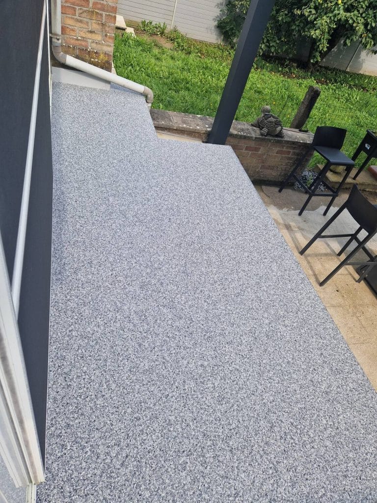Terrasse grise en tapis de pierres attenante au jardin — réalisation Sol Color