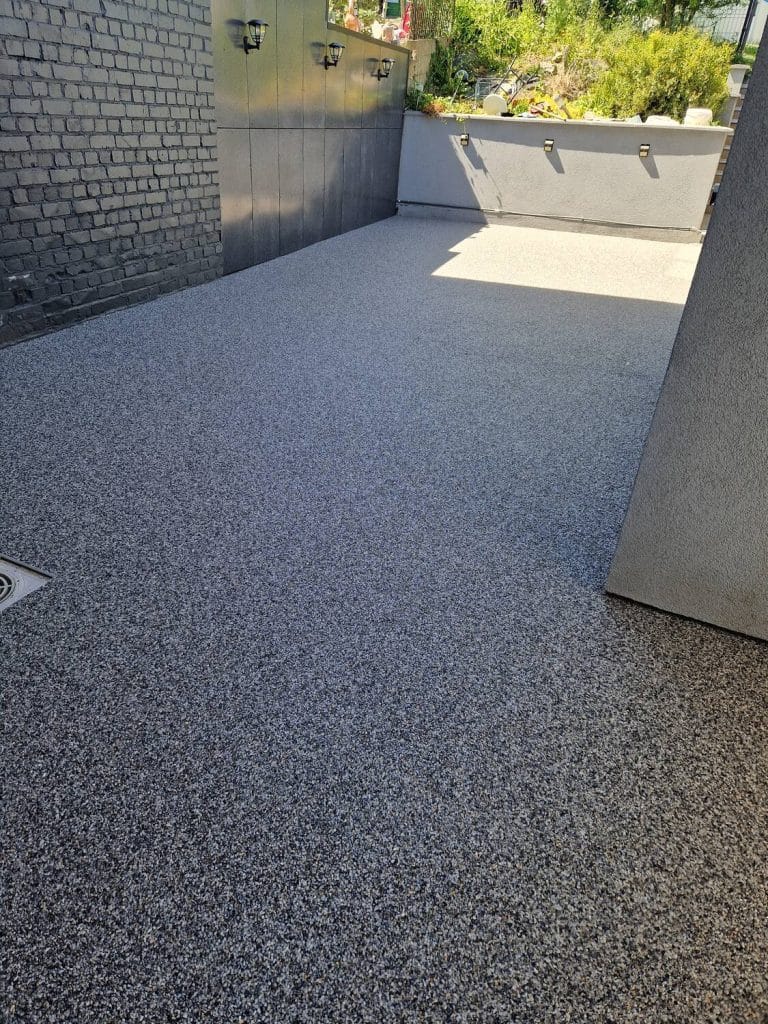 Terrasse contemporaine en tapis de pierres gris, drainante et antidérapante — Sol Color, Eupen